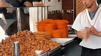 شاب يعمل في محل لبيع الحلويات الشعبية  